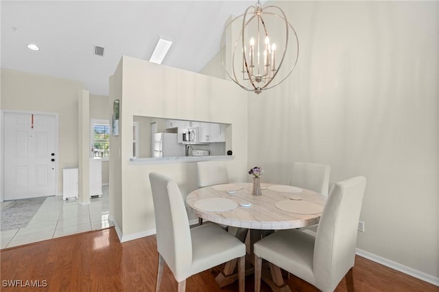 6660 Huntington Lakes Cir Unit 204, Naples, FL 34119 - dining space featuring baseboards, wood finished floors, a chandelier, and visible vents