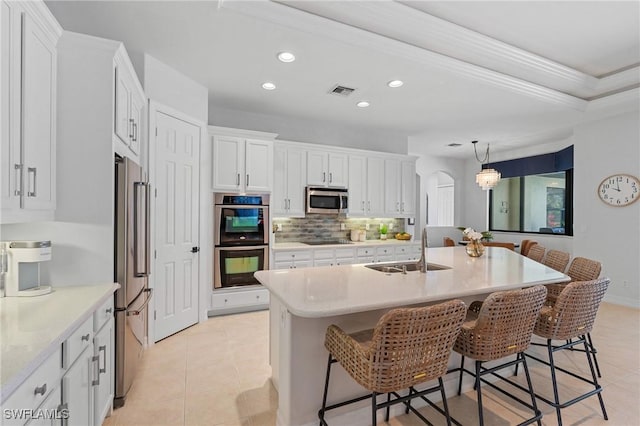 kitchen featuring recessed lighting, arched walkways, tasteful backsplash, a sink, and appliances with stainless steel finishes