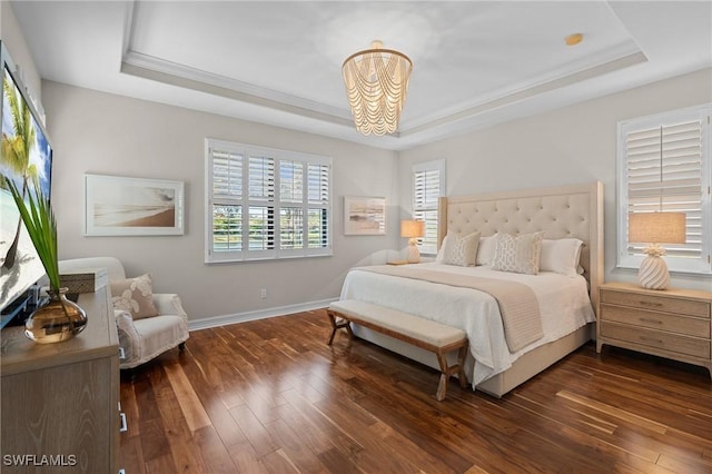 bedroom with dark wood-style flooring, a tray ceiling, a notable chandelier, and multiple windows