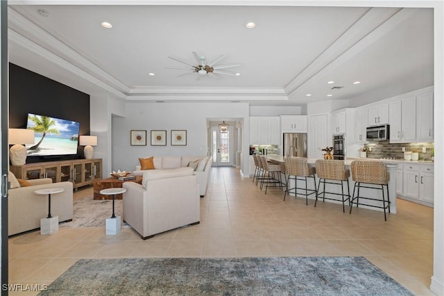 living area featuring recessed lighting, a raised ceiling, ceiling fan, and light tile patterned floors