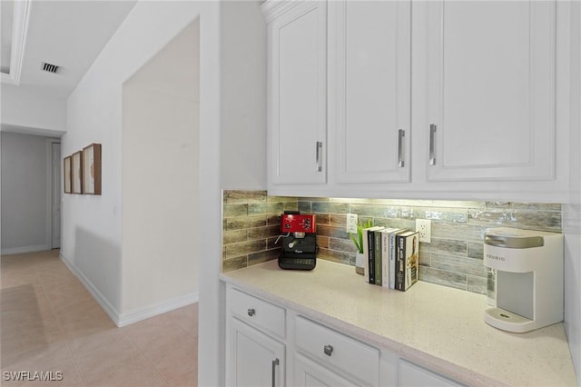 bar featuring light tile patterned flooring, baseboards, visible vents, and tasteful backsplash