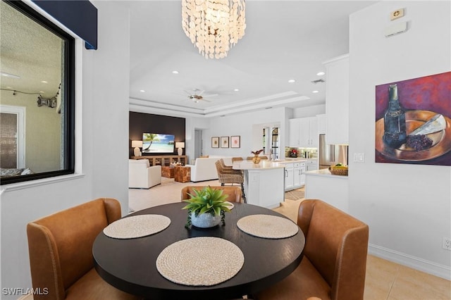 dining room featuring visible vents, light tile patterned floors, a raised ceiling, ceiling fan with notable chandelier, and recessed lighting