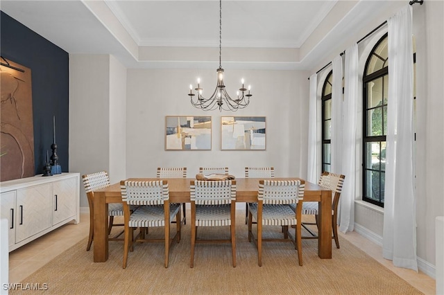 dining room with a chandelier, ornamental molding, light tile patterned floors, and a raised ceiling