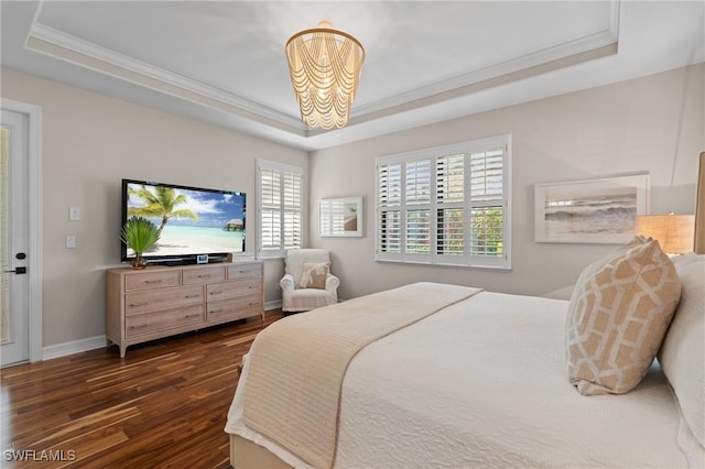 bedroom featuring crown molding, dark wood-style flooring, a raised ceiling, a chandelier, and baseboards