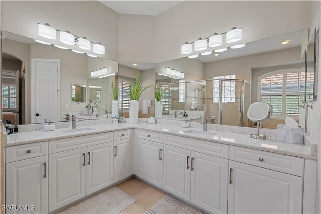bathroom with vanity, a healthy amount of sunlight, tile patterned flooring, and a stall shower