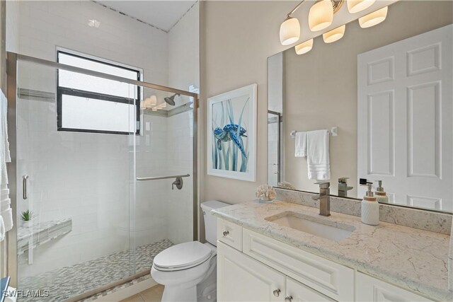 full bath with vanity, a shower stall, and toilet
