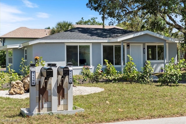 1115 Central Dr, Naples, FL 34104 - back of property featuring a lawn, stucco siding, and roof with shingles