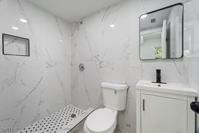 1115 Central Dr, Naples, FL 34104 - bathroom featuring visible vents, tile walls, vanity, toilet, and a marble finish shower