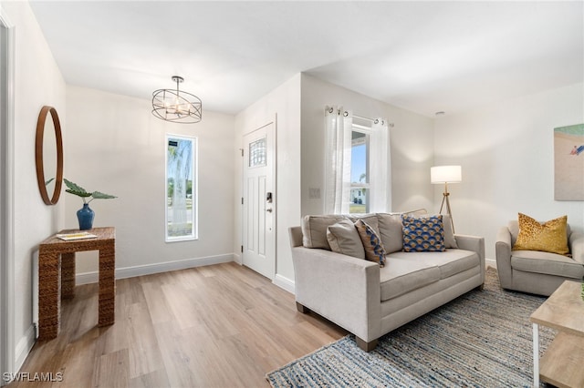 3565 Balboa Cir W, Naples, FL 34105 - living area featuring a chandelier, light wood-type flooring, and baseboards