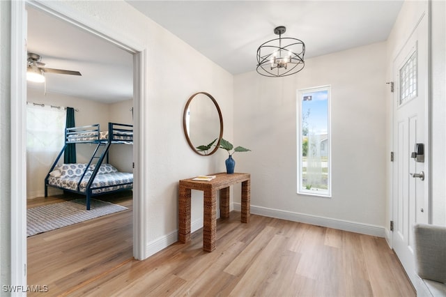 3565 Balboa Cir W, Naples, FL 34105 - foyer entrance with light wood-style floors, ceiling fan with notable chandelier, and baseboards
