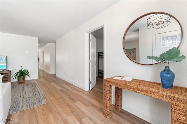 3565 Balboa Cir W, Naples, FL 34105 - corridor featuring baseboards, a notable chandelier, and light wood-style flooring