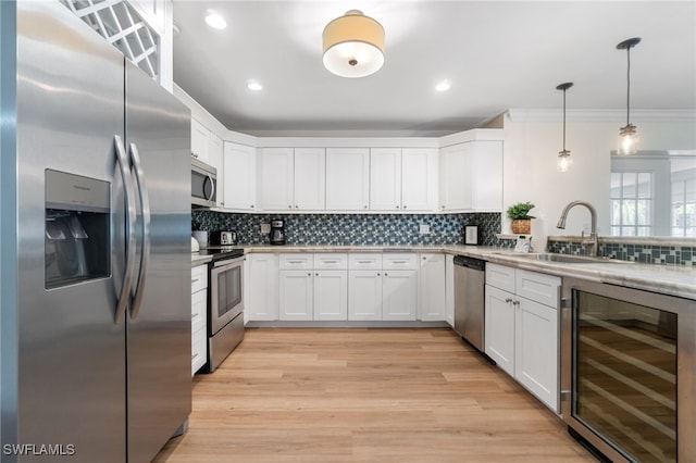 3565 Balboa Cir W, Naples, FL 34105 - kitchen featuring a sink, decorative backsplash, wine cooler, white cabinetry, and appliances with stainless steel finishes