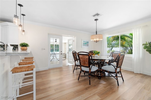 3565 Balboa Cir W, Naples, FL 34105 - dining room featuring crown molding, visible vents, light wood-style flooring, and baseboards