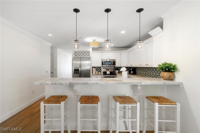 3565 Balboa Cir W, Naples, FL 34105 - kitchen featuring decorative backsplash, appliances with stainless steel finishes, baseboards, a peninsula, and crown molding
