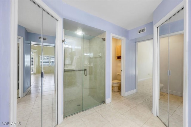 bathroom featuring visible vents, baseboards, toilet, and a shower stall