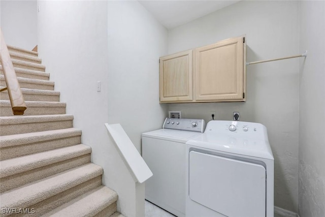 washroom featuring cabinet space and independent washer and dryer