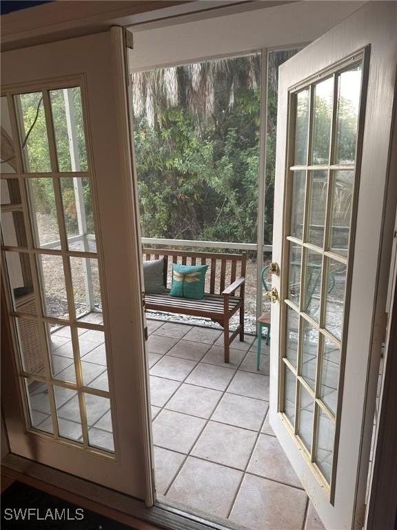 2385 Naples Trace Cir Unit 1, Naples, FL 34109 - doorway to outside with light tile patterned floors