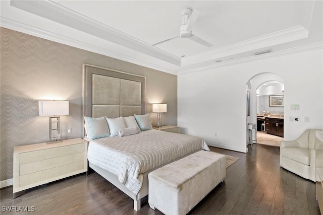 bedroom with arched walkways, ornamental molding, a raised ceiling, and dark wood-type flooring