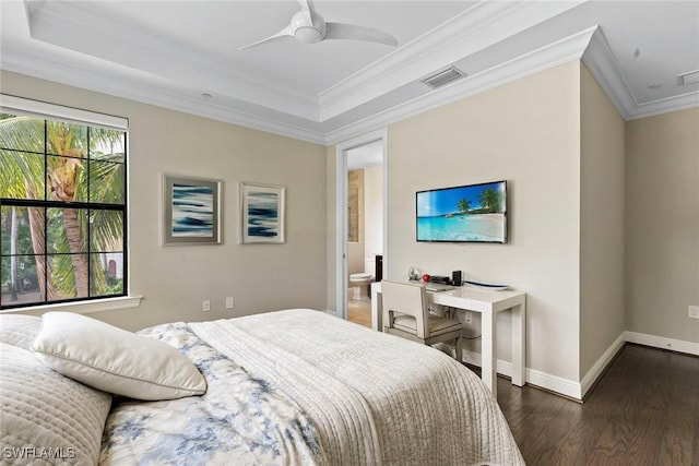 bedroom featuring baseboards, wood finished floors, a tray ceiling, visible vents, and ornamental molding
