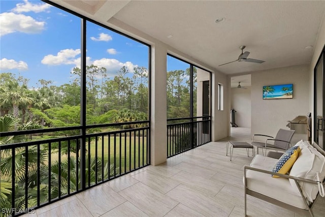 sunroom featuring expansive windows and a ceiling fan