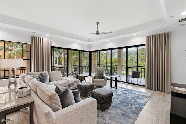 living room with ornamental molding, wood finished floors, ceiling fan, recessed lighting, and a tray ceiling