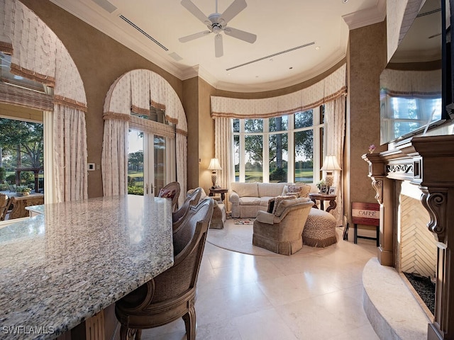 9663 Mashie Ct, Naples, FL 34108 - tiled living room with a high ceiling, plenty of natural light, ceiling fan, and crown molding