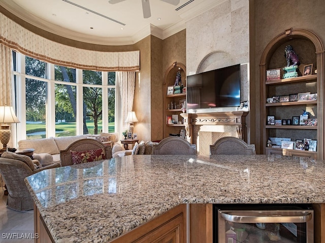 9663 Mashie Ct, Naples, FL 34108 - kitchen with wine cooler, open floor plan, crown molding, light stone counters, and ceiling fan