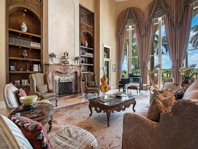 9663 Mashie Ct, Naples, FL 34108 - living area with built in shelves, a towering ceiling, healthy amount of natural light, a premium fireplace, and baseboards