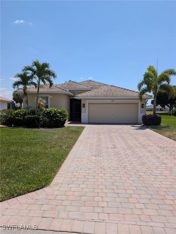single story home featuring a front lawn, decorative driveway, stucco siding, and a garage