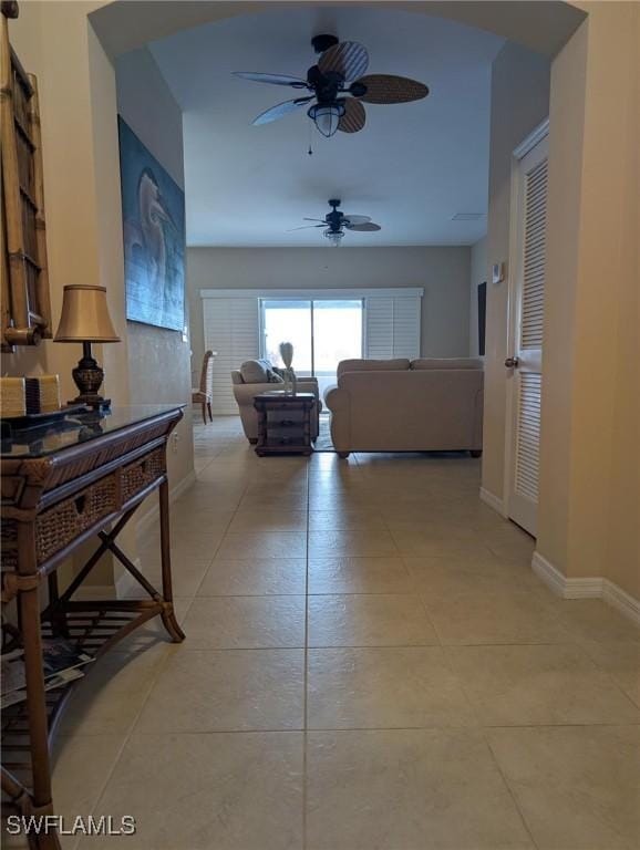 corridor with baseboards and light tile patterned floors