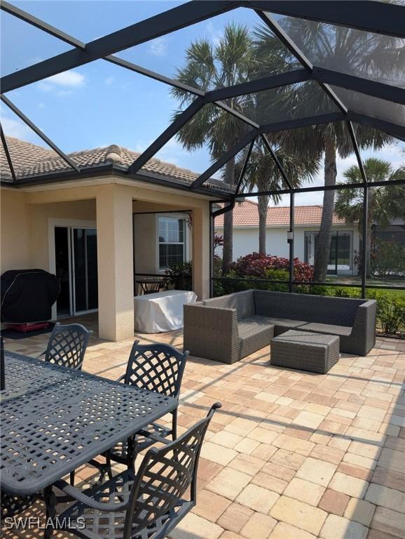 view of patio with an outdoor hangout area, glass enclosure, and outdoor dining area