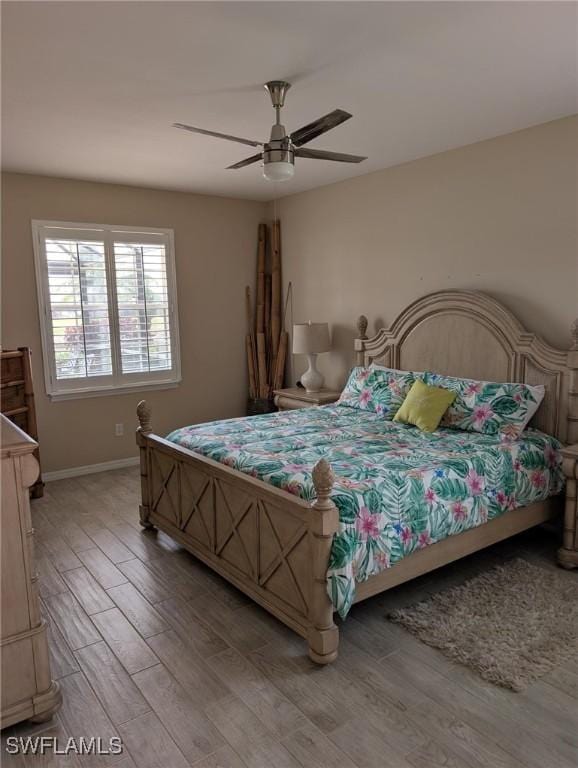 bedroom featuring a ceiling fan, baseboards, and light wood-style floors