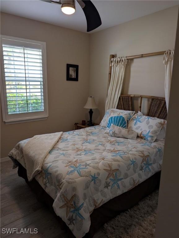 bedroom with baseboards, wood finished floors, and a ceiling fan
