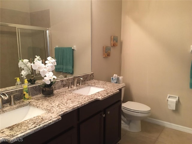 full bathroom featuring toilet, a shower stall, tile patterned flooring, and a sink