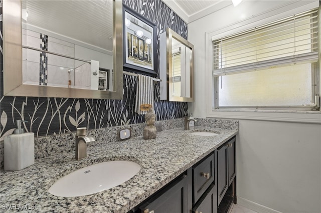 bathroom with a sink, baseboards, and double vanity