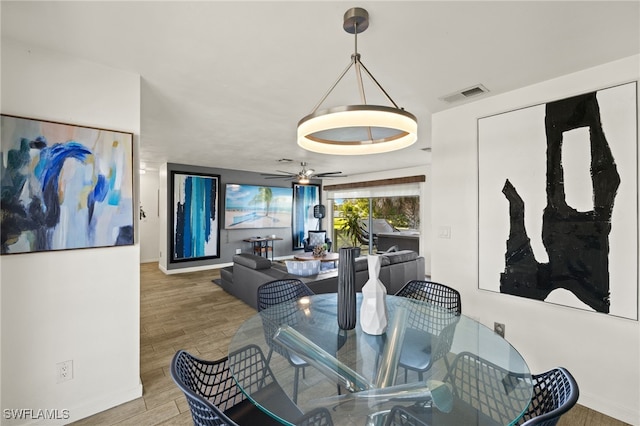 dining area featuring visible vents, baseboards, ceiling fan, and wood finished floors