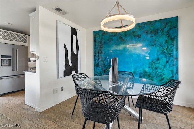 dining room featuring visible vents, baseboards, and wood finished floors