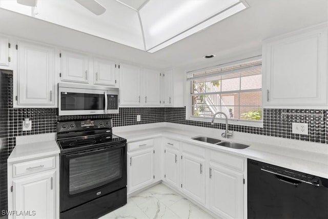 kitchen featuring white cabinets, a sink, light countertops, black appliances, and marble finish floor