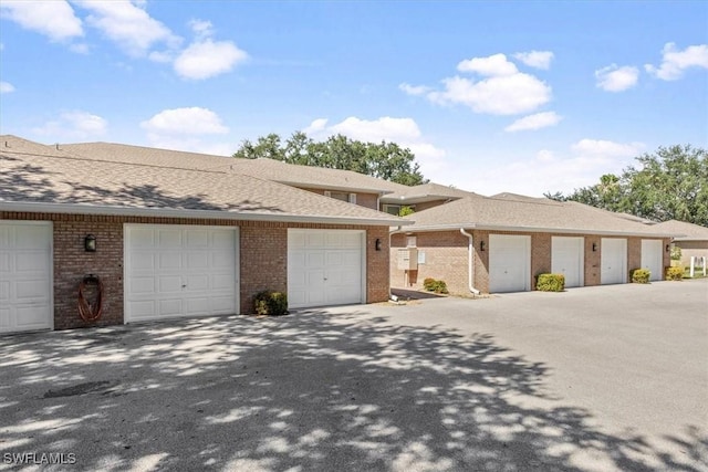 view of front of property featuring community garages and brick siding