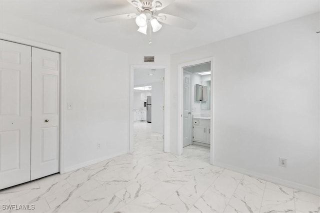 unfurnished bedroom featuring marble finish floor, visible vents, freestanding refrigerator, and baseboards