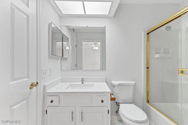 full bath with toilet, a ceiling fan, enclosed tub / shower combo, and vanity