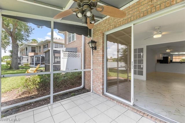 unfurnished sunroom with ceiling fan