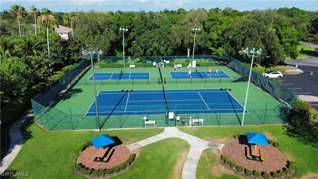 view of sport court featuring fence and a yard
