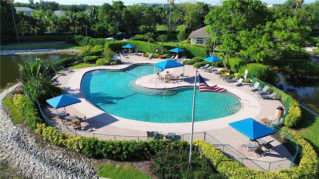 community pool with fence and a patio area