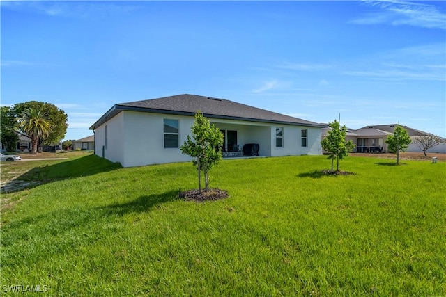 back of house featuring a yard and stucco siding