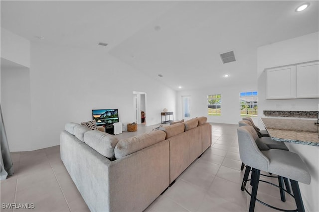 living room featuring lofted ceiling, light tile patterned floors, visible vents, and recessed lighting
