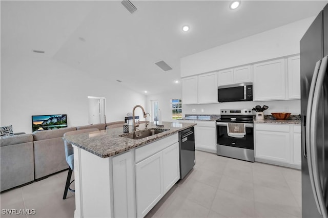kitchen featuring a sink, a breakfast bar area, light stone counters, white cabinets, and appliances with stainless steel finishes