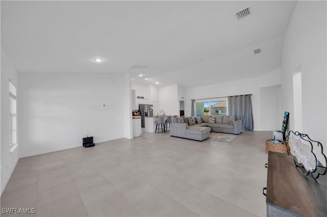 living room featuring visible vents, recessed lighting, and high vaulted ceiling