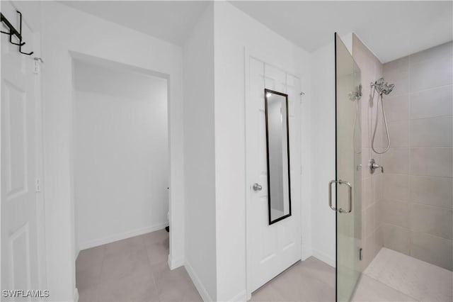 bathroom featuring tile patterned floors, a stall shower, and baseboards
