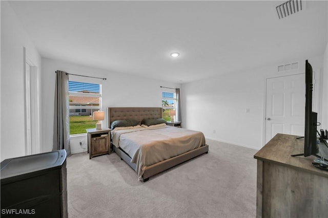 bedroom with recessed lighting, visible vents, light colored carpet, and baseboards